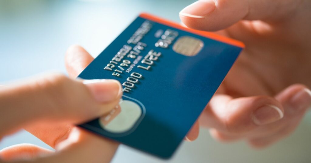 Credit card in hand, debt looming.